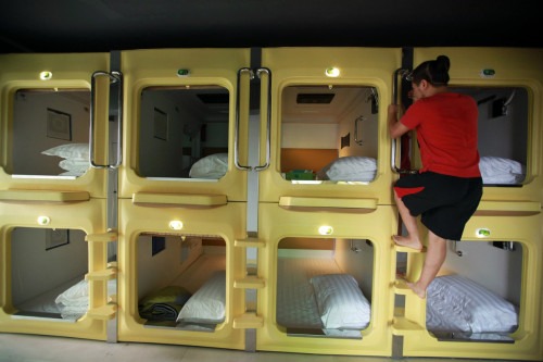 A guest climbs down a capsule in a newly opened capsule hotel in Haikou, south China's Hainan province on August 13, 2013. The capsules are the length and width of no more than a single bed and equipped with ventilating fans, flat-panel televisions and foldable tables. (Getty Images)