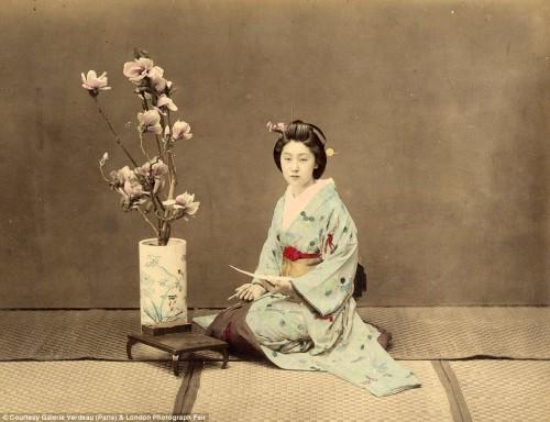 A geisha poses for a post card. Hard-tinted.